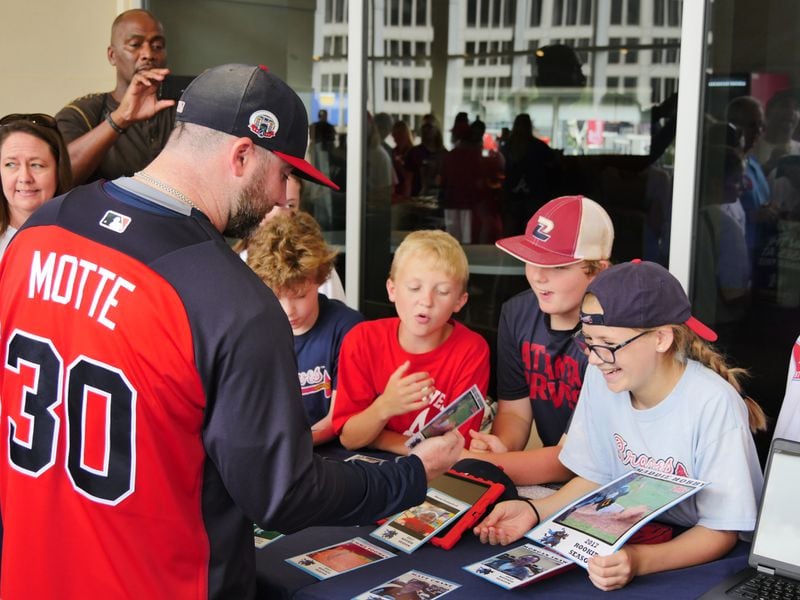 Braves relief pitcher Jason Mott talks to Mabry Middle School students about baseball cards they created using data collected during their Science of Baseball lessons. Credit: Richard Morris.