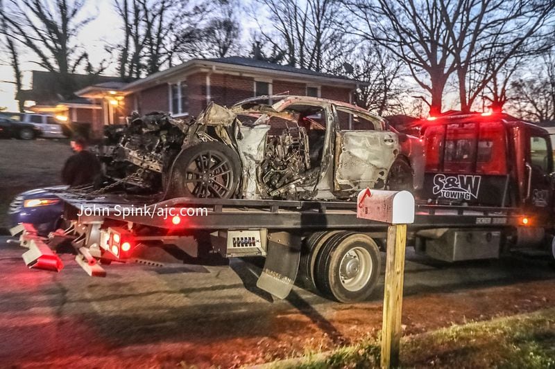A crumpled and charred Dodge Charger was loaded onto a trailer and towed from the scene.
