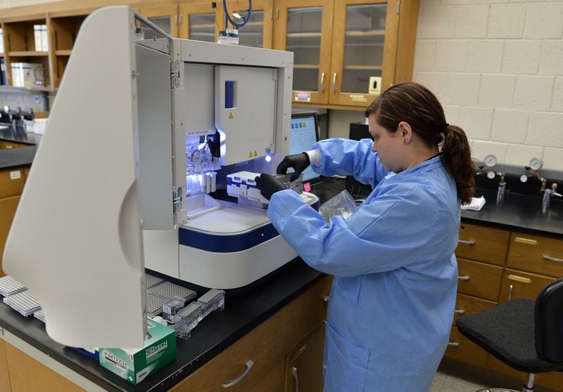 GBI forensic scientist Erin Norris uses a genetic analyzer to processes a rape kit at the GBI crime lab in Decatur. BRANT SANDERLIN/ AJC file / May 2015