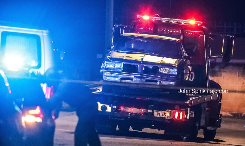 A car was towed from the scene of a triple shooting in DeKalb County. One man is dead and two others are in “extremely grave condition,” according to police. JOHN SPINK / JSPINK@AJC.COM