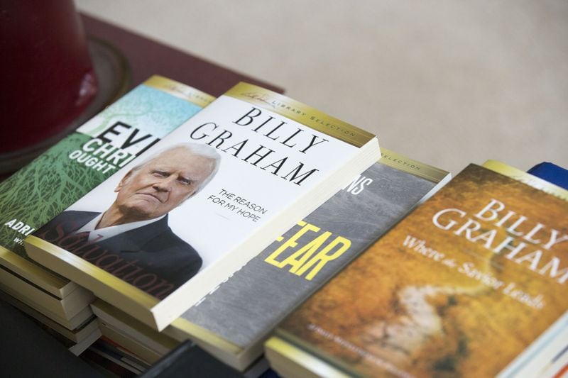 Books authored by Billy Graham rest on a coffee table in the living room of the Rev. Henry Holley’s house. ALYSSA POINTER / ALYSSA.POINTER@AJC.COM