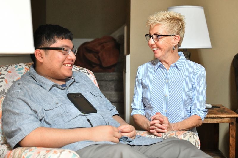 Carol Veschi shares a smile with one of her adopted children, John, 18, as they talk at their home in Alpharetta on Wednesday, September 9, 2020. (Hyosub Shin / Hyosub.Shin@ajc.com)