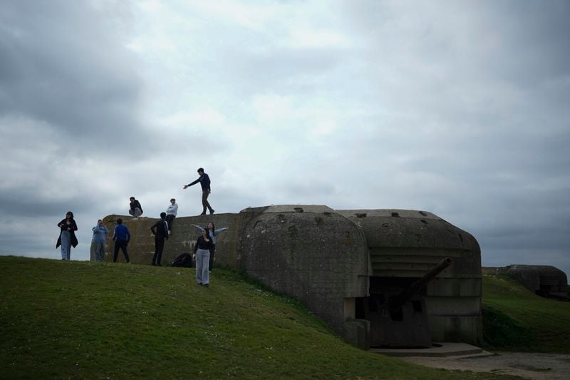Students walk by a bunker in Longues-sur-Mer, Normandy, Thursday, April 11, 2024. On D-Day, Charles Shay was a 19-year-old Native American army medic who was ready to give his life — and actually saved many. Now 99, he's spreading a message of peace with tireless dedication as he's about to take part in the 80th celebrations of the landings in Normandy that led to the liberation of France and Europe from Nazi Germany occupation. (AP Photo/Thibault Camus)