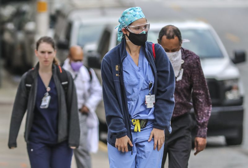 Grady Memorial Hospital medical personnel arrive for work on Tuesday, April 7, 2020, when for the second day in a row, the number of deaths from the coronavirus in Georgia rose sharply. JOHN SPINK/JSPINK@AJC.COM