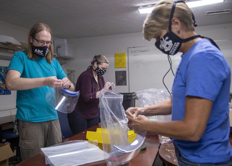 In this file photo, Irm Diorio (right), director of Decatur Makers, William Strika (left), executive director of Roswell Firelabs, and Skyler Holobach (center), co-founder of Atlanta Shield Makers, put together face shields at Roswell Firelabs in Roswell, Georgia. (Alyssa Pointer/Atlanta Journal-Constitution/TNS)
