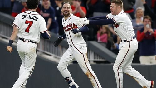 Ender Inciarte (center) is mobbed by celebrating teammates Dansby Swanson and Freddie Freeman after Inciarte’s walk-off bunt hit Saturday. (Photo by Mike Zarrilli/Getty Images)