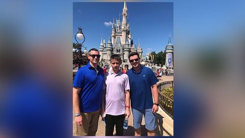Kevin Herrick and Zach Greene-Herrick pose with their son Richard in front of Cinderella Castle at Walt Disney World in fall 2019. Photo courtesy of Zach Greene-Herrick.