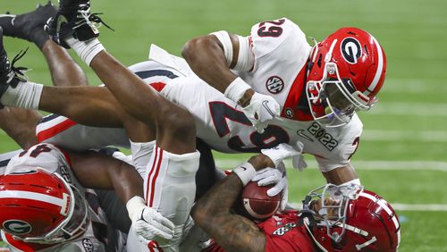 Georgia Bulldogs defensive back Christopher Smith (29) tackles Alabama Crimson Tide wide receiver Jameson Williams (1) for a 1-yard loss in the first quarter at the 2022 College Football Playoff National Championship at Lucas Oil Stadium in Indianapolis on Monday, Jan. 10, 2022. (Curtis Compton/The Atlanta Journal-Constitution/TNS)