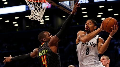 Brooklyn Nets guard Spencer Dinwiddie (8) looks to pass around Atlanta Hawks forward Paul Millsap (4) during the first half of an NBA basketball game Sunday, April 2, 2017, in New York. (AP Photo/Adam Hunger)