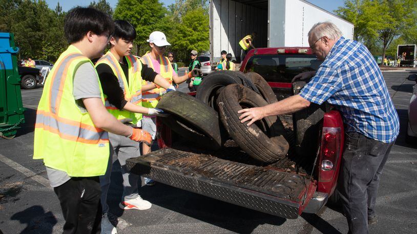Volunteers help lee Raymond (R) unload tires he brought to Gwinnett County's annual Earth Day event at Coolray Field in Lawrenceville Saturday, April 23, 2022. Each year, Gwinnett County Solid Waste Management and Gwinnett Clean & Beautiful celebrate Earth Day, allowing residents to drop off items typically challenging to recycle, such as electronics, latex, and oil-based paints, clothing, sneakers, and tires. (Steve Schaefer / steve.schaefer@ajc.com)