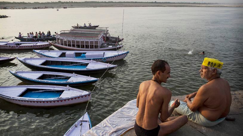 Two people talk after taking a dip on May 11, 2014 on the Ganges River in Varanasi, India. (Photo by Kevin Frayer/Getty Images)