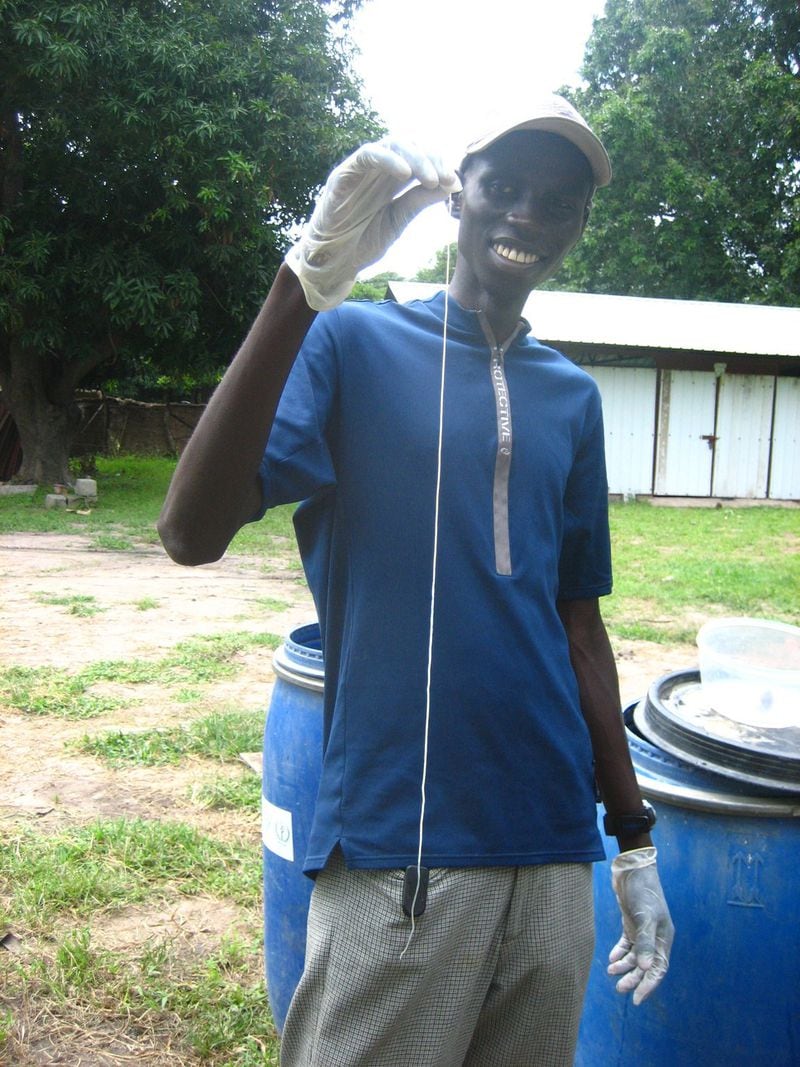 Garang Buk Buk Piol, who worked with the Carter Center in South Sudan helping eradicate Guinea worm disease, holds a worm that emerged from a patient’s body. Courtesy of David Stobbelaar.