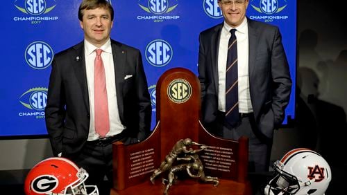 Georgia coach Kirby Smart (left) and Auburn coach Gus Malzahn pose with the SEC championship trophy during an NCAA college football news conference in Atlanta on Friday.