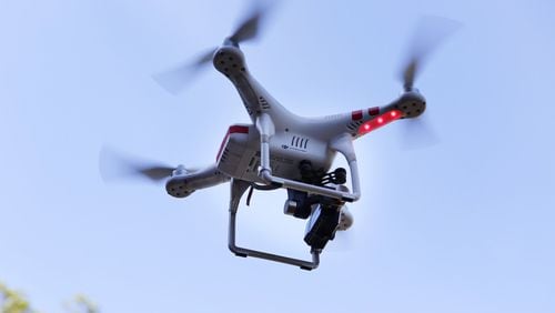 A DJI Phantom 2 drone controlled by drone videographer Curt Walton hovers to shoot aerial video above a multimillion-dollar home for sale in the hills above Saratoga, Calif., on Feb. 25, 2016. Federal aviation regulators issued long-awaited commercial drone rules on Tuesday. (Gary Reyes/Bay Area News Group/TNS)