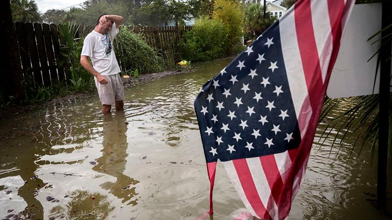 Tybee Island resident Joe Murphy wipes the sweat off his face while standing in knee deep water from Tropical Storm Irma outside his house, Monday, Sept., 11, 2017, on Tybee Island, Ga. (AP Photo/Stephen B. Morton)
