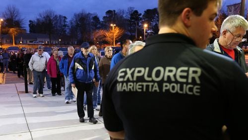 Brent Gunkle, with the Marietta Police Explorers, watches the door as hundreds of people arrive for an active shooter seminar put on by the police department Dec. 9 at Marietta High School. Ben Gray / bgray@ajc.com