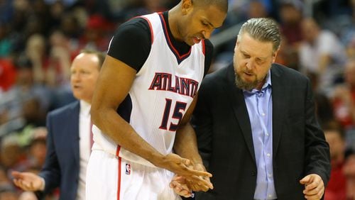 Hawks head trainer Wally Blase checks center Al Horford’s hand after he dislocated his pinky finger against the Nets during an NBA playoff basketball game on Sunday, April 19, 2015, in Atlanta. Curtis Compton / ccompton@ajc.com