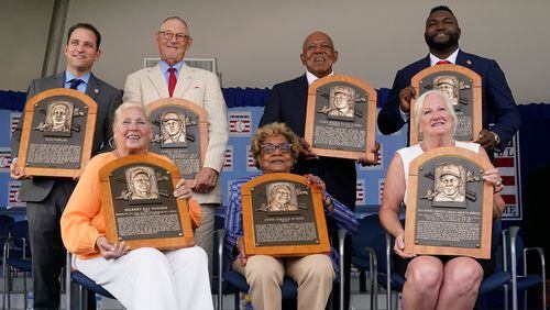 Clockwise from top left, Josh Rawitch, president of the National Baseball Hall of Fame and Museum, holding the plaque of inductee Bud Fowler, inductee Jim Kaat, inductee Tony Oliva, inductee David Ortiz, Sharon Rice-Minoso, holding the plaque of her husband and inductee Minnie Minoso, Dr. Angela Terry, holding the plaque of her uncle and inductee John Jordan O'Neil, and Irene Hodges, holding the plaque of her father and inductee Gil Hodges, pose for a photo at the conclusion of the National Baseball Hall of Fame induction ceremony, Sunday, July 24, 2022, at the Clark Sports Center in Cooperstown, N.Y. (AP Photo/John Minchillo)