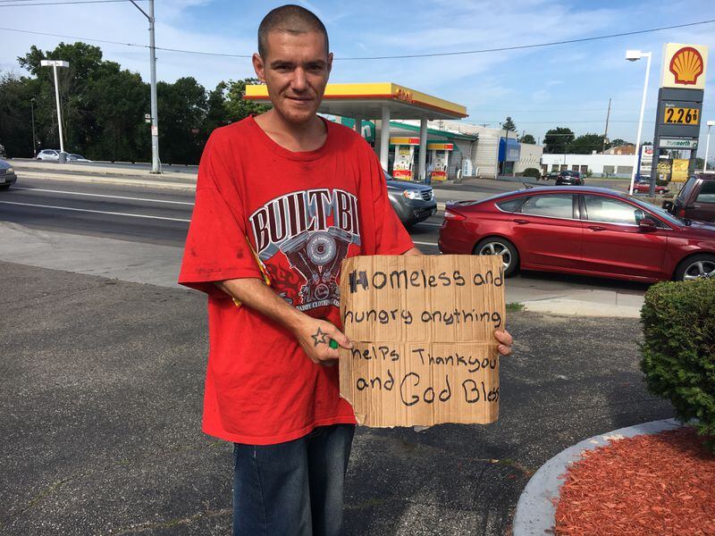 Charles Young holds a sign near the intersection of U.S. 35 and Smithville Road. “I’ve been looking for a job. It’s just been rough. I don’t want to do this. I want to get off the street,” he said.