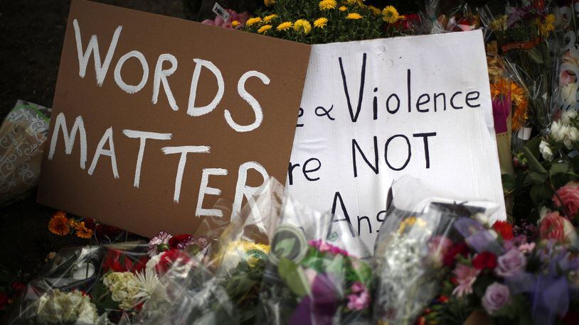 Flowers surround signs on Wednesday, Oct. 31, 2018, part of a makeshift memorial outside the Tree of Life Synagogue to the 11 people killed during worship services Saturday Oct. 27, 2018 in Pittsburgh. (AP Photo/Gene J. Puskar)