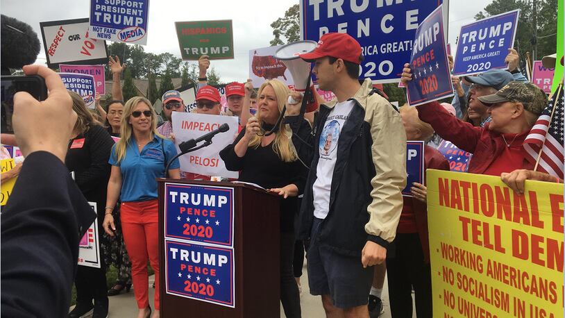 Julianne Thompson addresses a crowd of President Donald Trump supporters protesting outside Rep. Lucy McBath's Sandy Springs office.