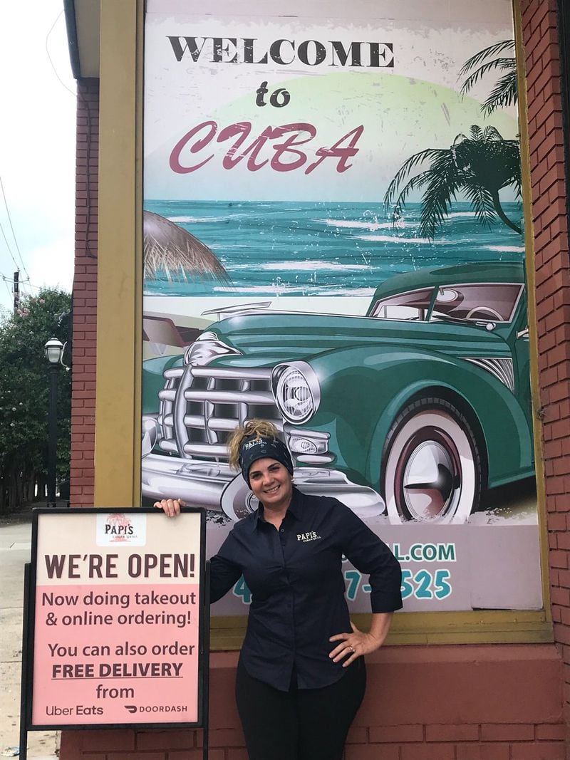 Papi’s Cuban and Caribbean Grill co-owner and executive chef Teresa Regalado stands at the entrance to the restaurant’s Midtown location on Ponce De Leon Avenue. When Regalado’s husband Rey started the concept in 2003, it was a 534-square-foot sandwich shop called Papi s East Cuban. Papi’s has since expanded, with a total of six locations, including a franchise at the airport. LIGAYA FIGUERAS/LIGAYA.FIGUERAS@AJC.COM