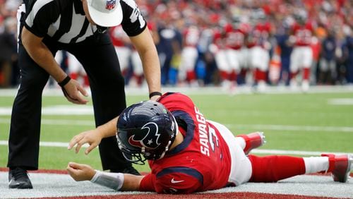 Referee John Hussey checks on Houston Texans quarterback Tom Savage following the hit Sunday that left him concussed. (AP Photo/The Galveston County Daily News, Kevin M. Cox)