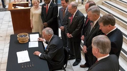 April 27, 2017, Atlanta - Governor Nathan Deal signs House Bill 338, which aims to turn around low-performing schools. (DAVID BARNES / DAVID.BARNES@AJC.COM)