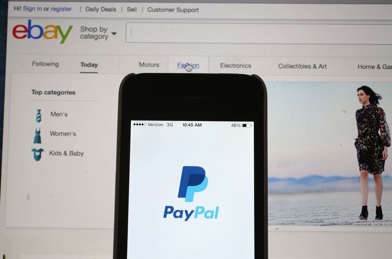 MIAMI, FL - SEPTEMBER 30:  In this photo illustration, an eBay website is seen on a computer screen and the PayPal website is seen on an iphone on September 30, 2014 in Miami, Florida.  Today, eBay announced it will split from the payments service PayPal, forming two independently traded companies beginning in 2015.  (Photo by Joe Raedle/Getty Images)