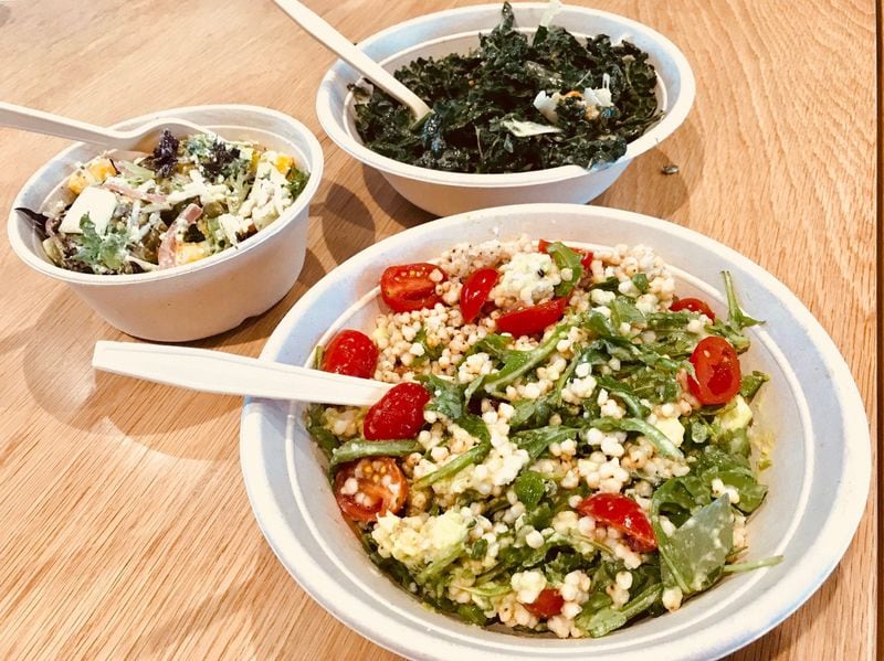 Salads from Wildleaf (clockwise from left): create-your-own with artisan greens, mango, jicama, green papaya, pickled red onion and queso fresco; Catalan salad with Tuscan kale, medjool dates, hazelnuts and manchego cheese; and Ancient Grains salad with sorghum seed, wild arugula, avocado, cherry tomatoes and basil. LIGAYA FIGUERAS / LFIGUERAS@AJC.COM