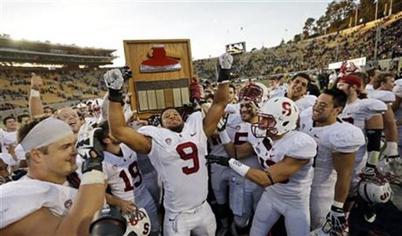 Stanford players, including James Vaughters (9), run with the Stanford Axe after defeating California 38-17 on Saturday, Nov. 22, 2014, in Berkeley, Calif. (AP Photo/Ben Margot)