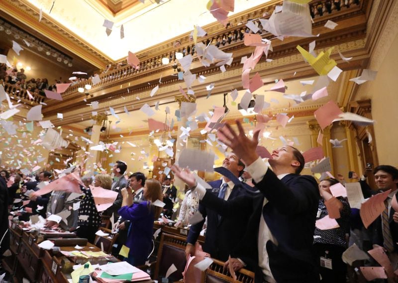 Papers are thrown into the air shortly after midnight at the conclusion of Thursday’s Legislative Day 40 in the Senate chamber at the Georgia Capitol in Atlanta. (PHOTO: JASON GETZ / FOR THE AJC)