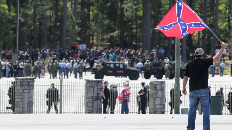 MOUNTAIN OF PROTEST--April 23, 2016 Stone Mountain: Joseph Andrews, one of a small group with the Rock Stone Mountain rally, waves a confederate battle flag towards a mass of counter-protesters more than 100 yards away at Stone Mountain Park on Saturday afternoon April 23, 2016 where a white power protest and two counter protests were scheduled. Ben Gray / bgray@ajc.com