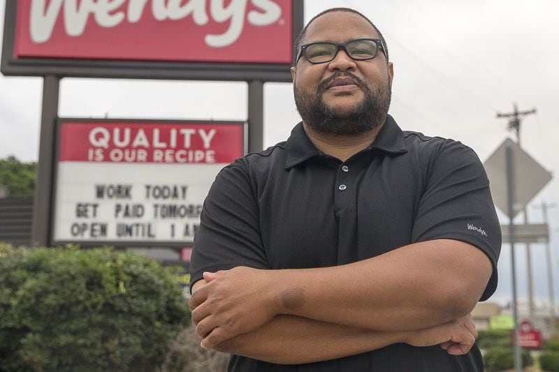 Thomas Williams poses for a portrait before heading to his job at Wendy’s in Marietta on July 10. He has found it hard to find a job in his finance field, instead picking up odd jobs along the way. (Alyssa Pointer/alyssa.pointer@ajc.com)