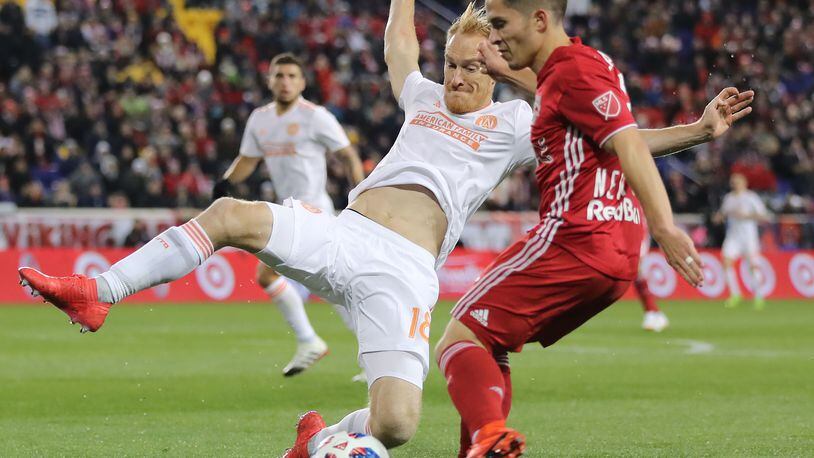 Atlanta United's Jeff Larentowicz throws himself into the job of defending Connor Lade  of the New York Red Bulls during the MLS Cup semifinals.