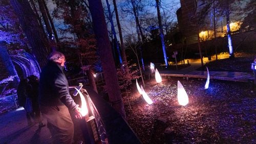 A man interacts with the Wildwoods: AGLOW Experience at the Fernbank Museum in Atlanta, GA, on Friday, December 2, 2022.(Photo/Jenn Finch)
