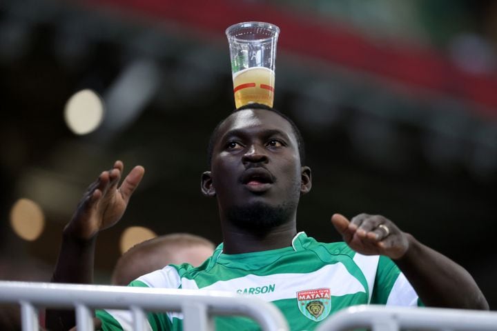 A soccer fan balances a glass of beer on his head during the match. JASON GETZ FOR THE ATLANTA JOURNAL-CONSTITUTION