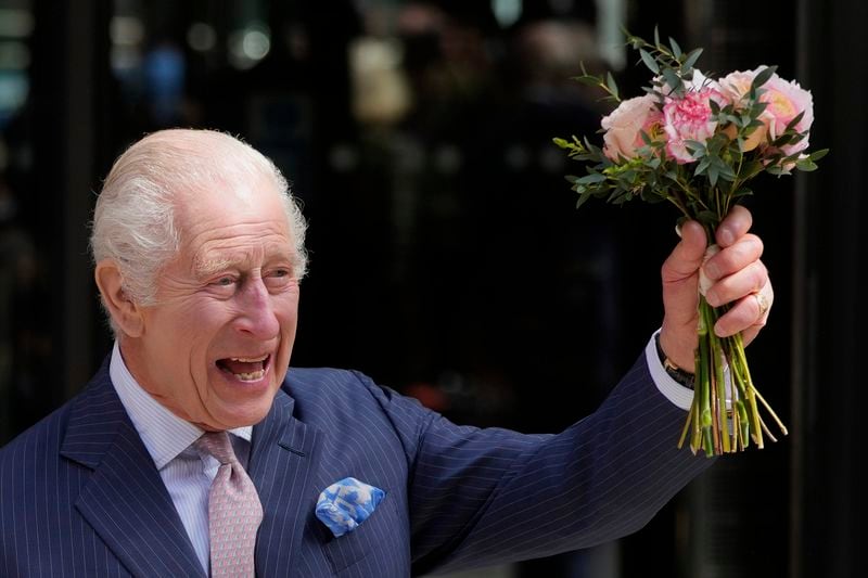 Britain's King Charles III holds up flowers he was given as he leaves after a visit to University College Hospital Macmillan Cancer Centre in London, Tuesday, April 30, 2024. The King, Patron of Cancer Research UK and Macmillan Cancer Support, and Queen Camilla visited the University College Hospital Macmillan Cancer Centre, meeting patients and staff. This visit is to raise awareness of the importance of early diagnosis and will highlight some of the innovative research, supported by Cancer Research UK, which is taking place at the hospital. (AP Photo/Kin Cheung)