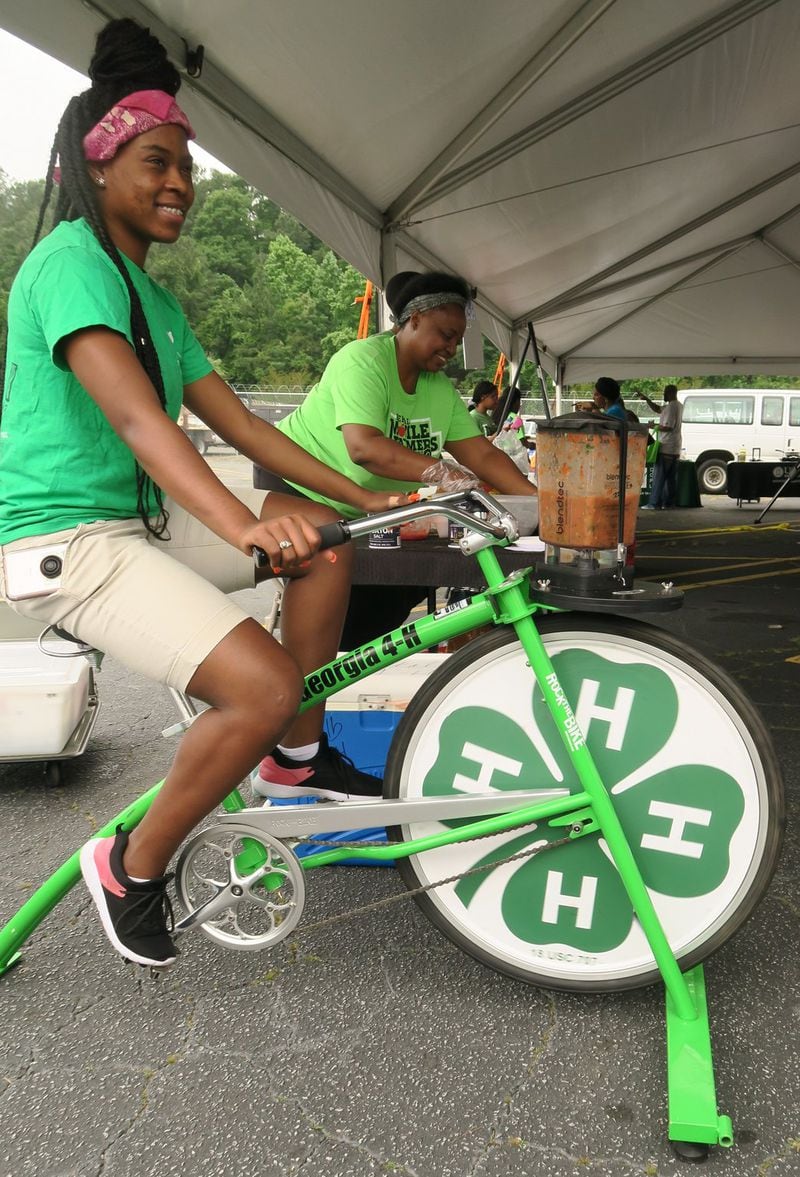 At the kickoff event for the 2018 season of Fresh on Dek, Ariana Cherry rides a stationary bicycle emblazoned with the 4-H logo. As she turns the pedals, the front wheel powers a blender chopping tomatoes, onion and cilantro for a delicious, low-salt, no-fat salsa. Photo: Marcia Killingsworth