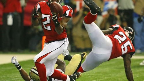Falcons cornerback Robert McClain intercepts a pass intended for Saints wide receiver Brandin Cooks in the endzone during the third quarter in their NFL football game on Sunday, Sept. 7, 2014, in Atlanta. Falcons safety William Moore (right) helps defend on the play.