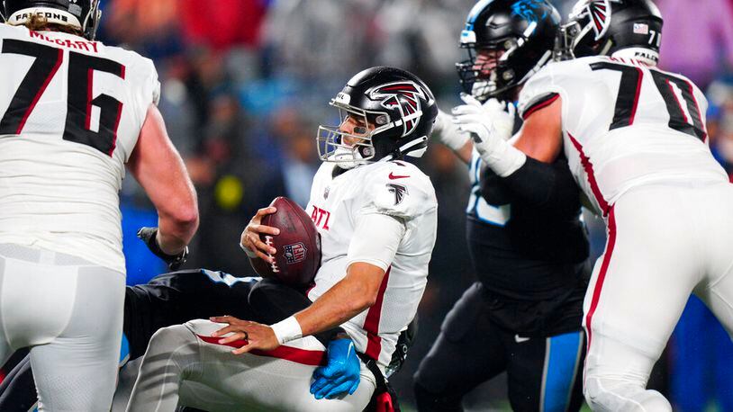 Atlanta Falcons quarterback Marcus Mariota is sacked by Carolina Panthers defensive end Marquis Haynes Sr. during the second half of an NFL football game on Thursday, Nov. 10, 2022, in Charlotte, N.C. (AP Photo/Jacob Kupferman)