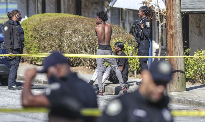 Atlanta police talk to two young men in the wake of the shooting of a 15-year-old boy at Oakland City West End Apartments in March. Police say that the crime that has become astonishingly routine in many complexes often is committed by people who do not live at the properties. (John Spink / John.Spink@ajc.com)
