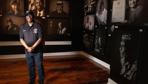 Vietnam Veteran Sgt. Johnny Miller poses for photographs in front of a series of portraits of Black Vietnam War veterans now on display at the Marietta History Center Tuesday, June 27, 2023. (Steve Schaefer/steve.schaefer@ajc.com)