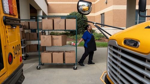Gwinnett County cafeteria workers bring freshly prepared food out to waiting school buses in front of Berkmar High School so they can be delivered to students around the district in April. Ben@BenGray.com for the Atlanta Journal-Constitution