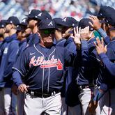 Atlanta Braves manager Brian Snitker high-fives members of the Braves before an opening day baseball game against the Washington Nationals at Nationals Park, Thursday, March 30, 2023, in Washington.