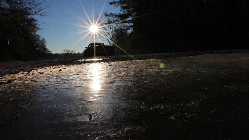 A truck passes by a large patch of black ice covering the edge of Hwy 142 in Newton County in 2017.    Curtis Compton/ccompton@ajc.com