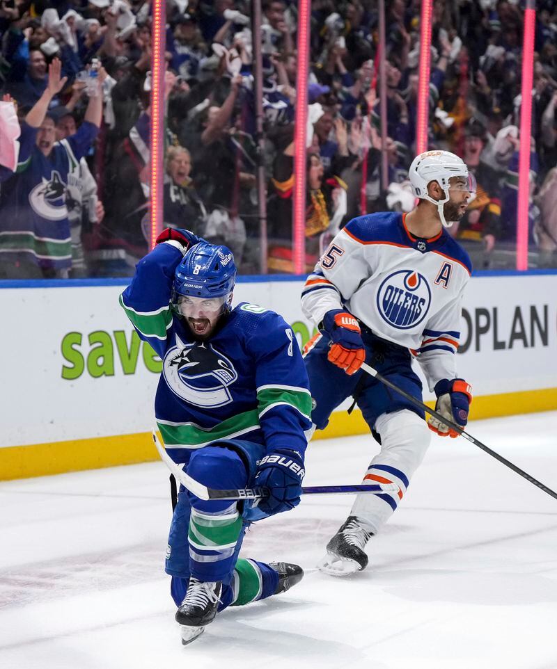 Vancouver Canucks' Conor Garland, left, celebrates his goal, next to Edmonton Oilers' Darnell Nurse during the third period of Game 1 of a second-round NHL hockey Stanley Cup playoffs series, Wednesday, May 8, 2024, in Vancouver, British Columbia. (Darryl Dyck/The Canadian Press via AP)