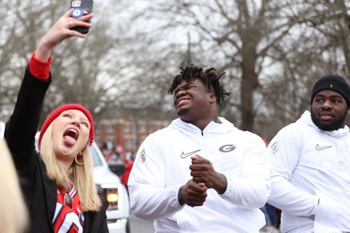 Georgia defensive tackle Jordan Davis reacts with a fan who takes a selfie during the victory parade that flies through the UGA  campus on Saturday, January 15, 2022. Miguel Martinez for The Atlanta Journal-Constitution