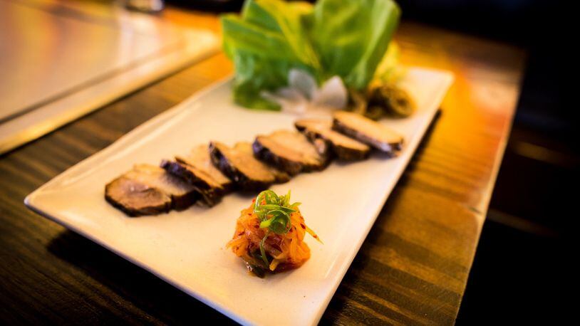 A plate of bossam includes braised pork belly, lettuce wraps and house-made kimchi. (Theodore Williams)