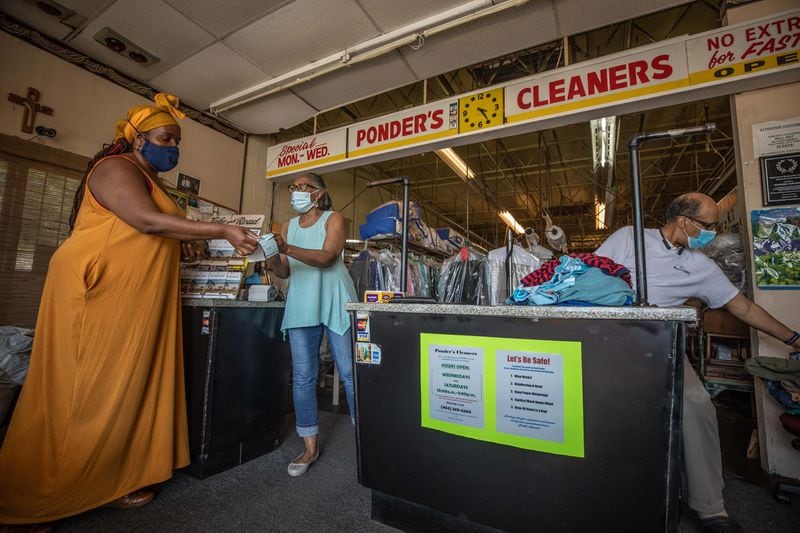 Ponder’s Cleaners owner Deborah Ponder (center) hands a receipt to a customer as her husband, Roderick Ponder, sorts clothing at their business in Atlanta, Saturday, June 13, 2020. (Photo: Branden Camp for The Atlanta Journal-Constitution)
